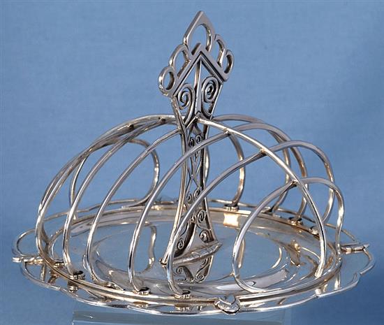 A good George V Arts & Crafts silver seven bar toast rack, Diameter :7 ¼”/183mm Height 5 ¼”/135mm Weight: 17.2oz/487grms